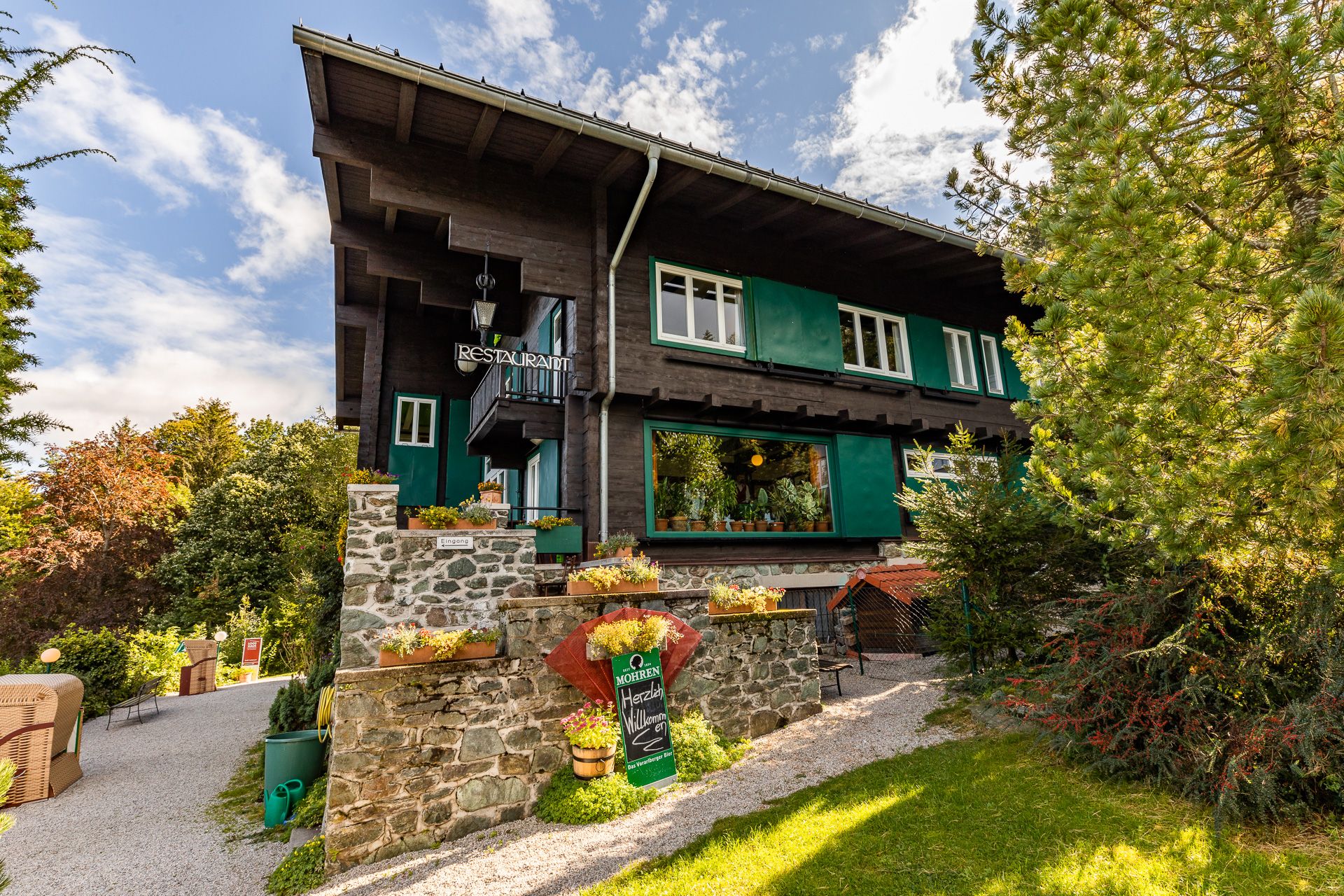Looshaus am Kreuzberg, ein traditionelles Gebäude mit Restaurant, umgeben von Bäumen und Garten.