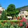 Ein malerisches Hotel mit bunten Blumen im Vordergrund und einem Schloss im Hintergrund.