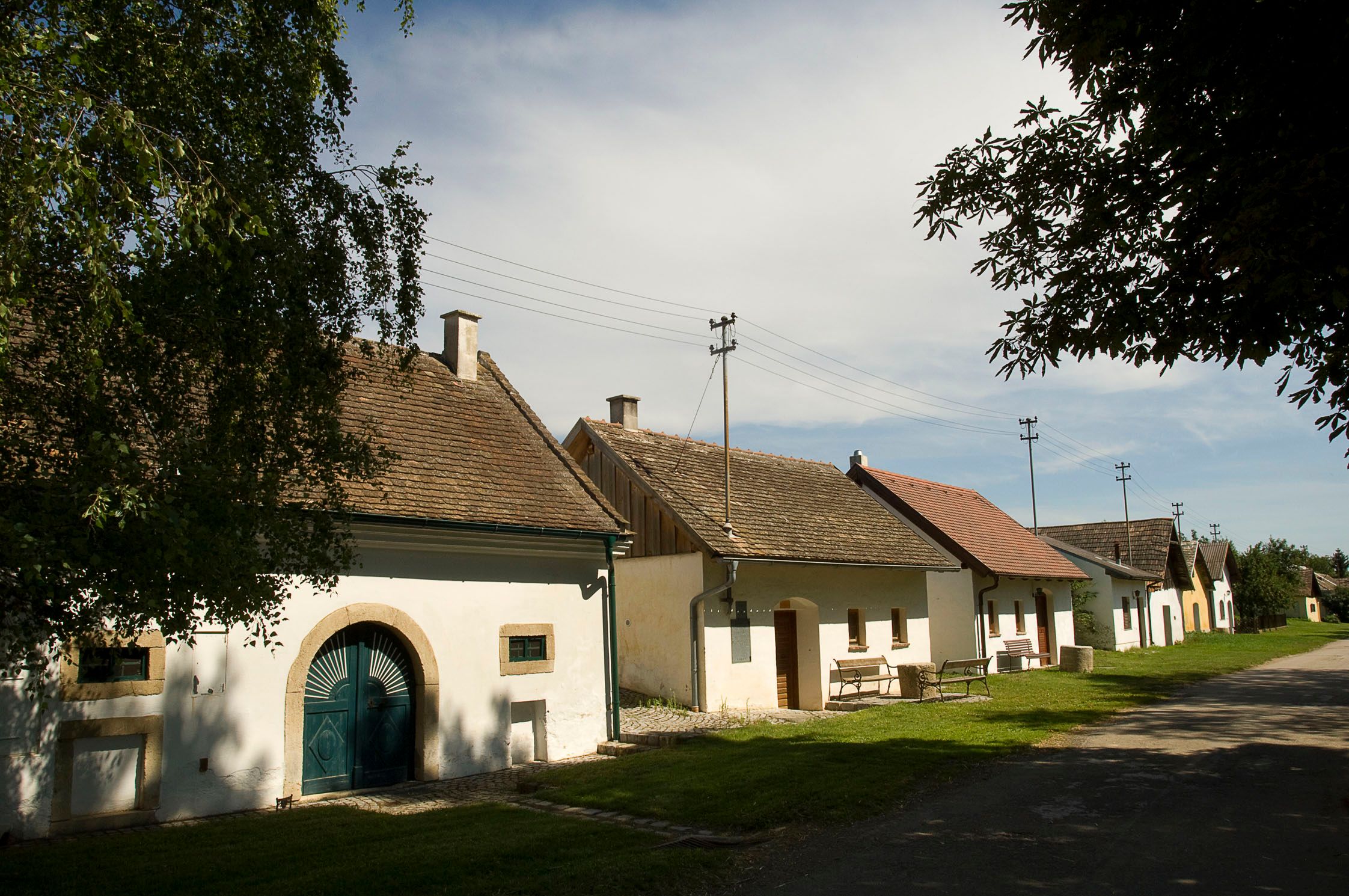 Reihe von Weinkellern in Schöngrabern, Österreich, bei sonnigem Wetter.