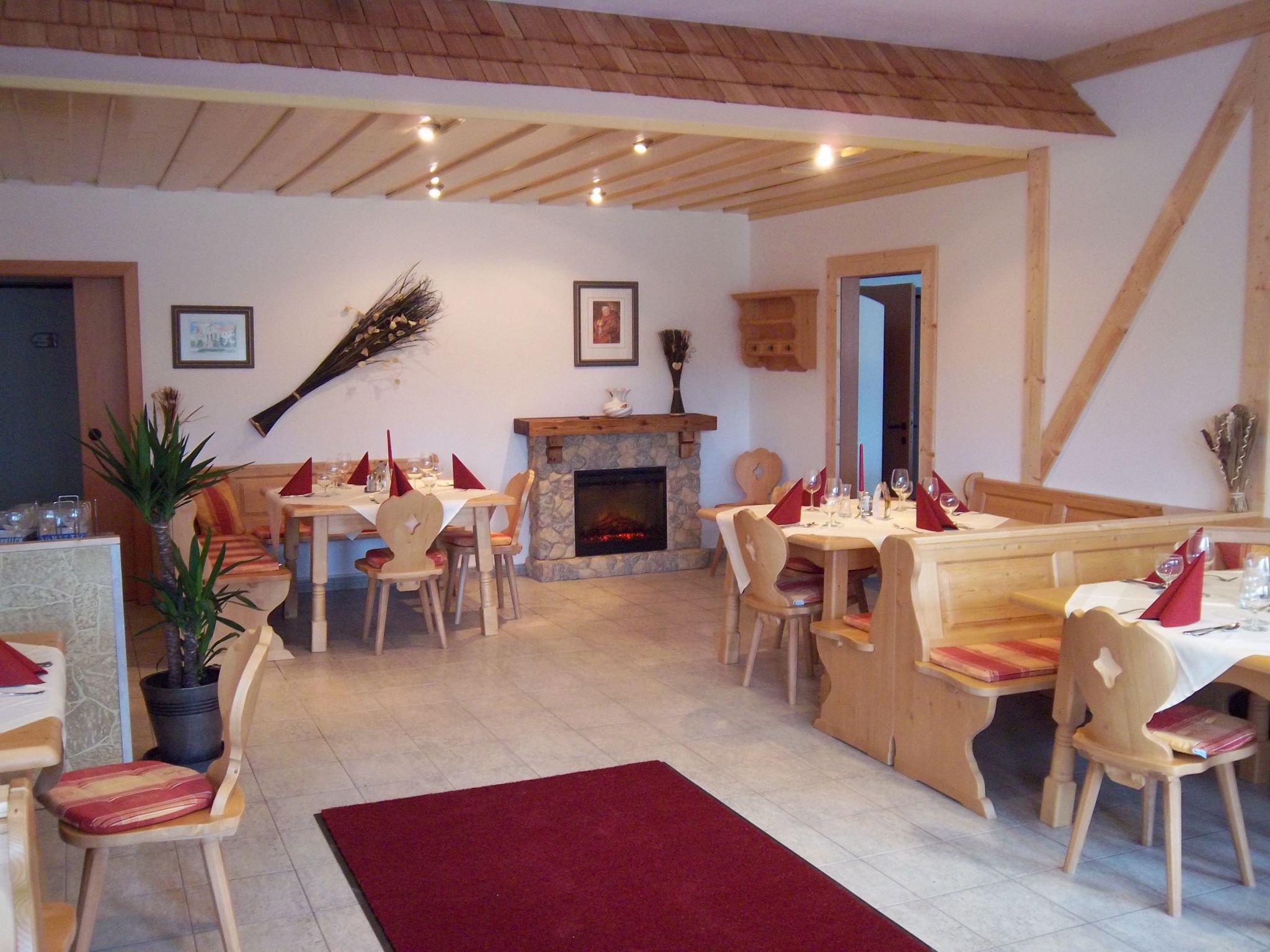 Gemütlicher Gastraum mit Holzmöbeln und Kamin.