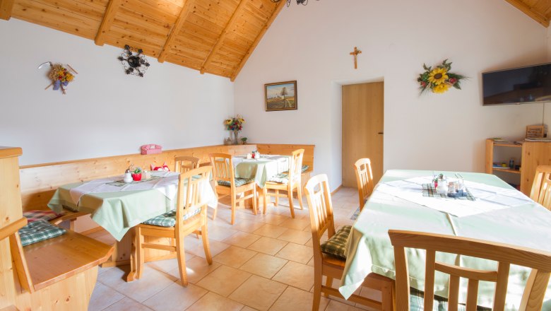 Gemütlicher Raum mit Holzmöbeln und dekorierten Tischen.