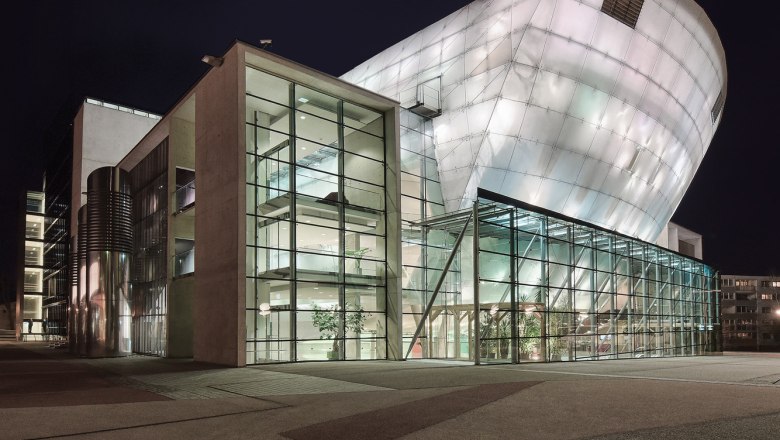 Nachtaufnahme des Festspielhauses St. Pölten mit beleuchteter moderner Architektur.