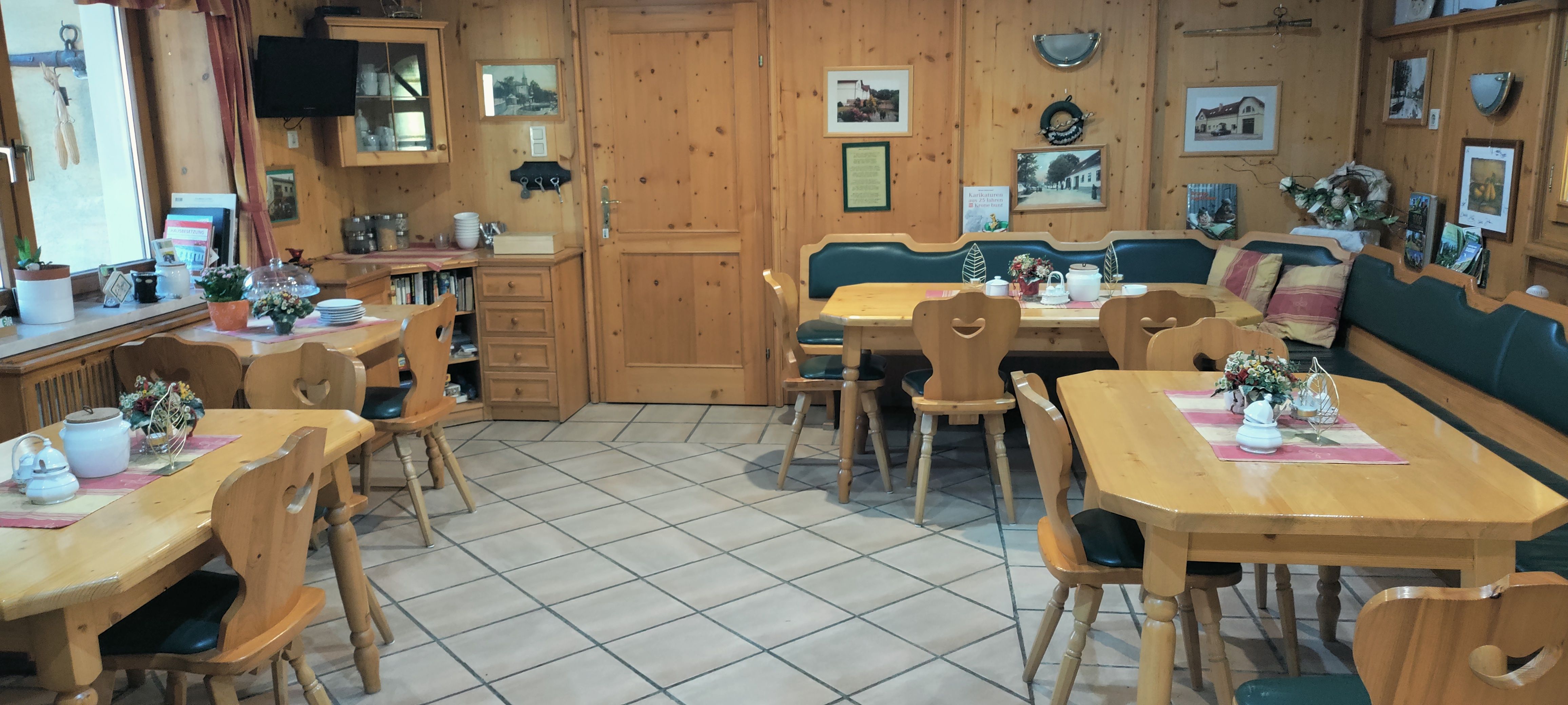 Gemütlicher Frühstücksraum mit Holzmöbeln und Dekorationen.