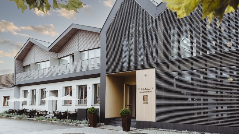 Modernes Hotelgeb&auml;ude mit Terrasse und stilvoller Fassade.