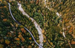 Die bunten Blätter der Bäume leuchten im warmen Licht des Herbstes und laden zu einem entspannenden Spaziergang ein. Der sanfte Fluss schlängelt sich durch die malerische Landschaft, während die majestätischen Berge im Hintergrund eine beeindruckende Kulisse bieten. Hier, in der unberührten Natur, findet jeder Besucher Ruhe und Inspiration.