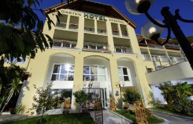 Außenansicht des Gartenhotel Pfeffel mit gelber Fassade und Balkonen.