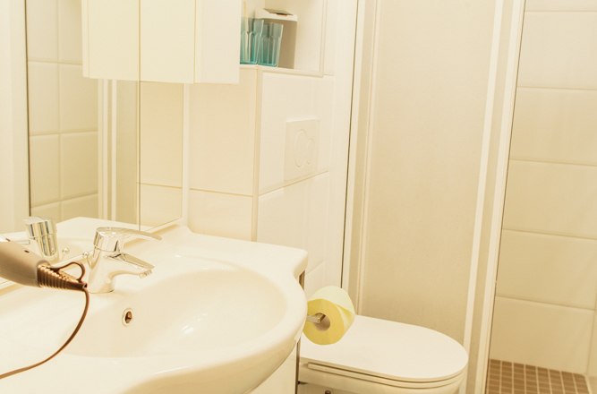 Modernes Badezimmer mit Waschbecken, Toilette und Dusche.