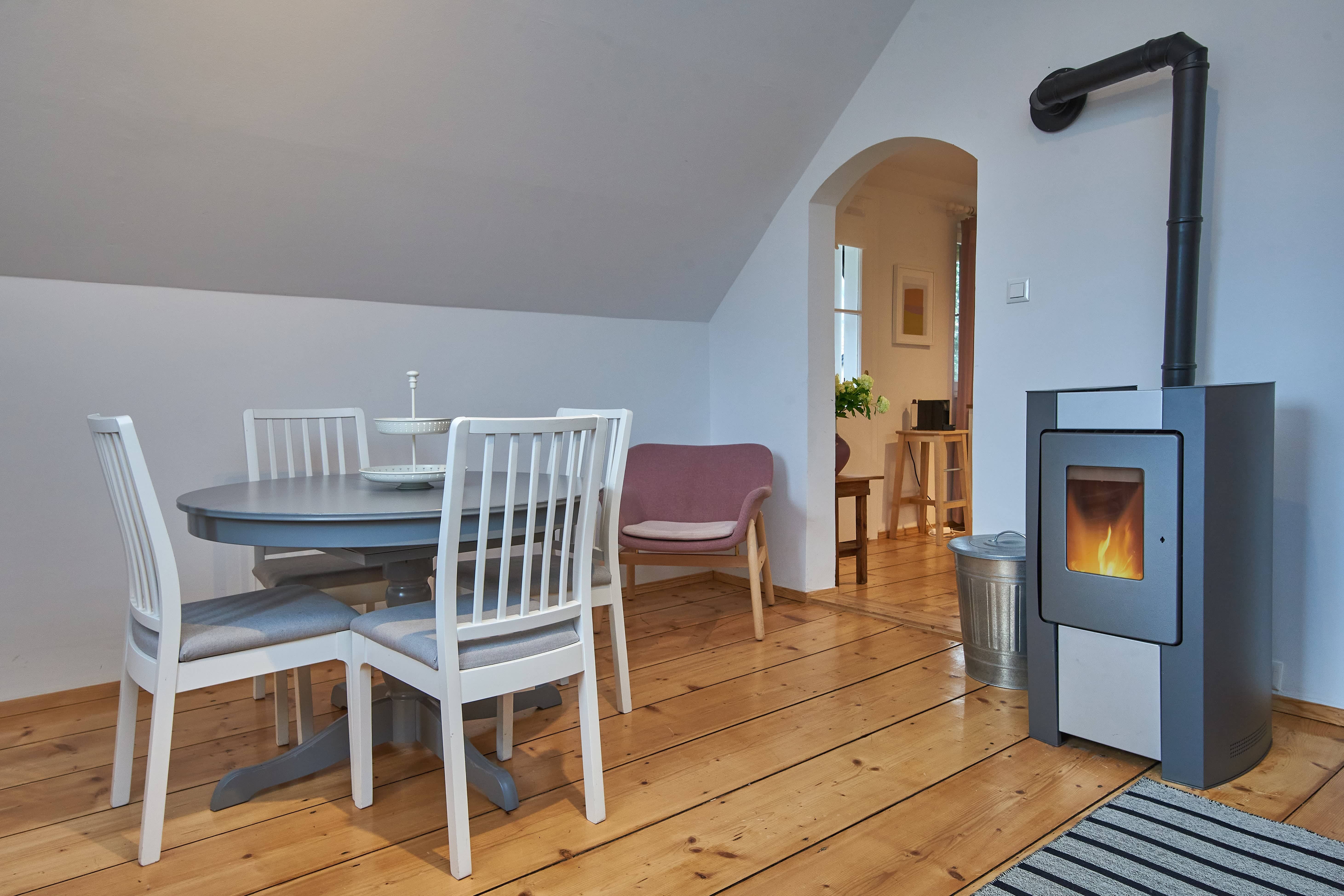 Gemütliches Wohnzimmer mit Esstisch, Stühlen, Sessel und Kamin.