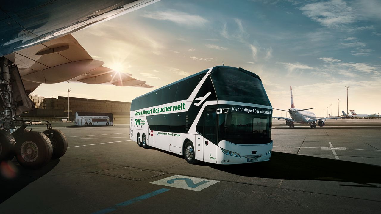 Besucherbus der Flughafen Wien Besucherwelt auf dem Vorfeld zwischen Flugzeugen – bei einer Tour erleben Gäste den Flughafenbetrieb aus nächster Nähe.