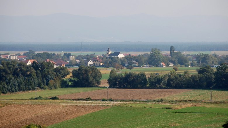 Landschaft mit Feldern und Dorf im Hintergrund, Weikersdorf am Steinfelde.