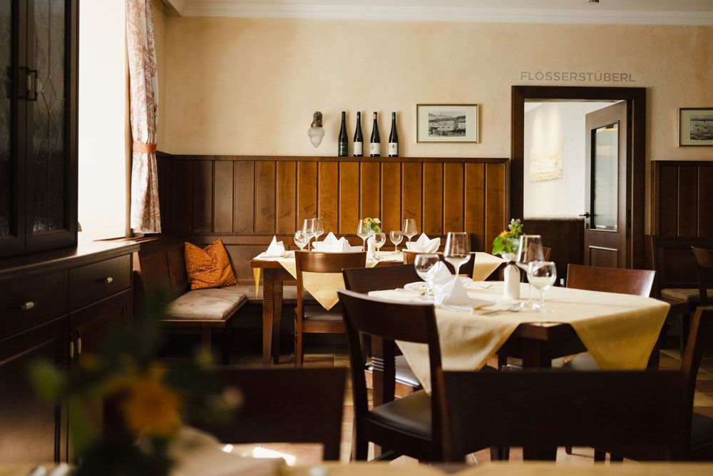 Gemütliches Restaurant mit Holzmöbeln und gedeckten Tischen.