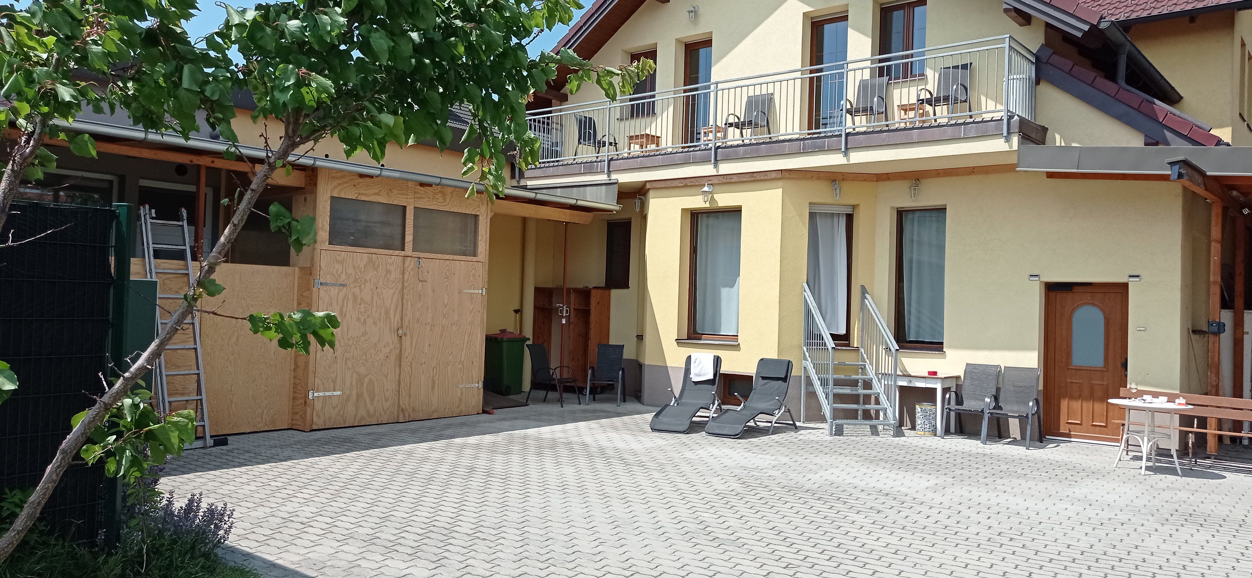 Haus von außen mit gelber Fassade und Balkon 