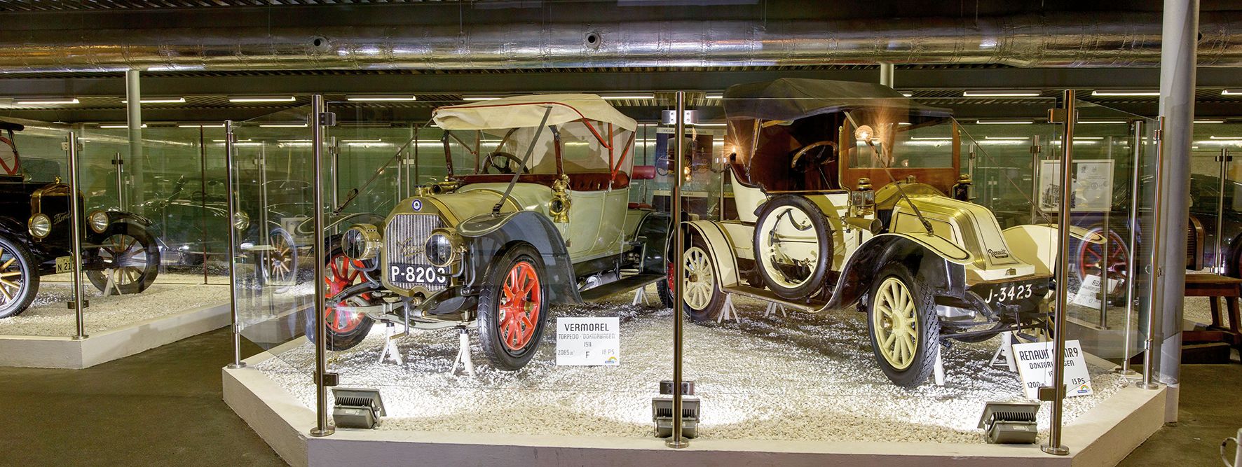 Historische Autos im Automobilmuseum hinter Glas ausgestellt.
