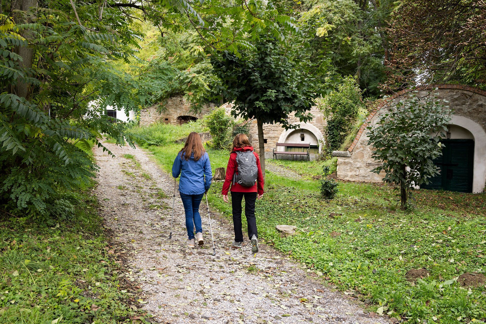 Zwei Frauen auf einem Wanderweg durch ein Kellerviertel. 