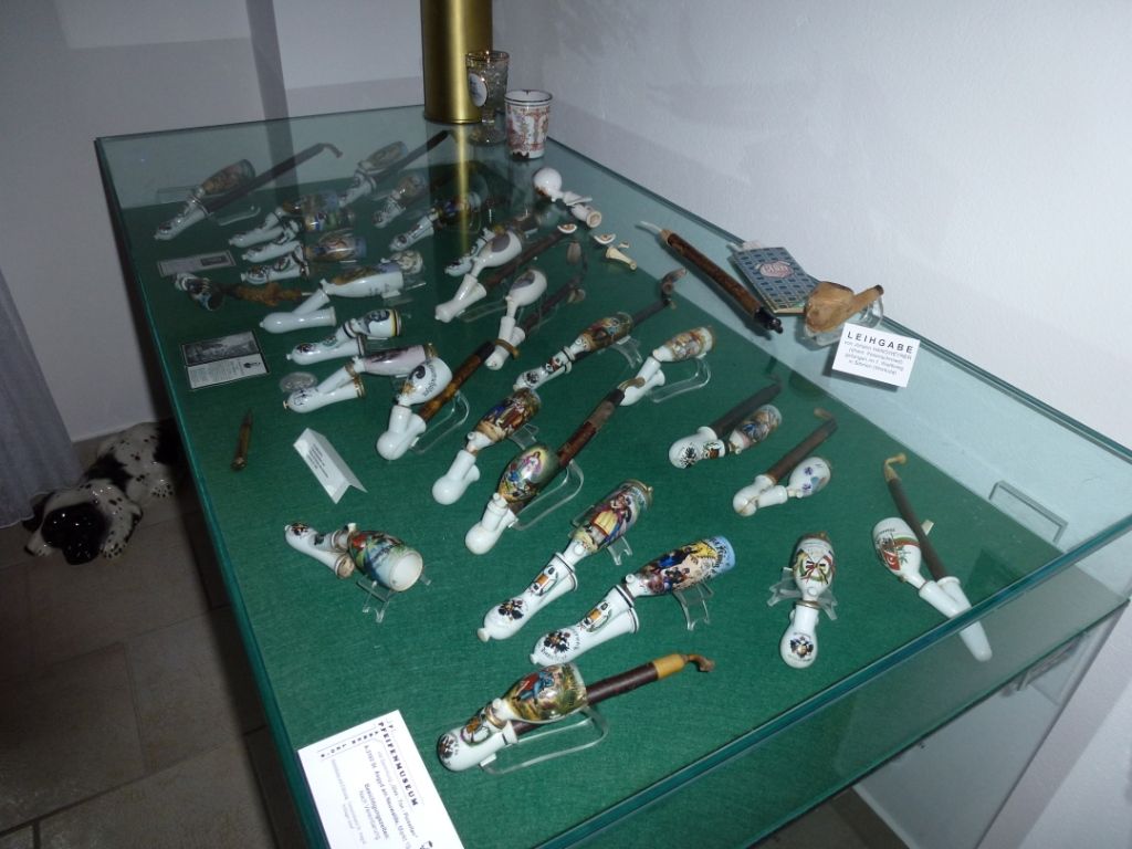 Vitrine mit dekorativen Pfeifen in einem Museum.