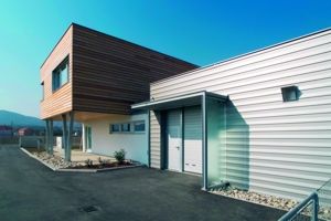 Modernes Gebäude mit Holz- und Metallfassade, klarer Himmel.