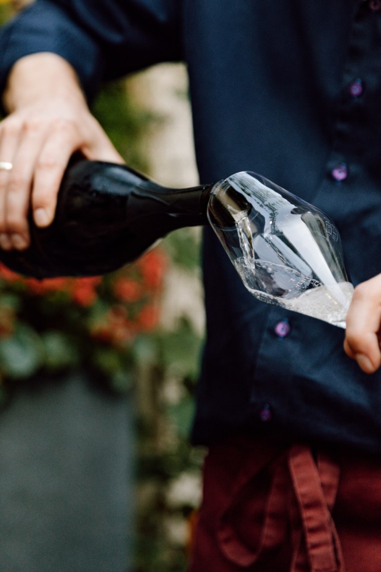 Hand schenkt Weinglas ein