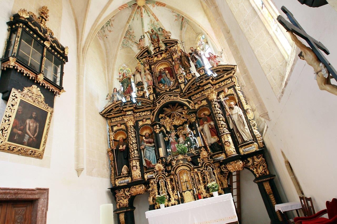 Innenansicht der Wallfahrtskirche Annaberg mit reich verziertem Altar und religiösen Statuen.