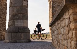 Ein Radfahrer genießt die majestätische Kulisse des Heidentors, während die warmen Sonnenstrahlen die alten Steine umspielen. Die sanfte Brise und die malerische Landschaft laden dazu ein, die Schönheit der Natur in vollen Zügen zu erleben.