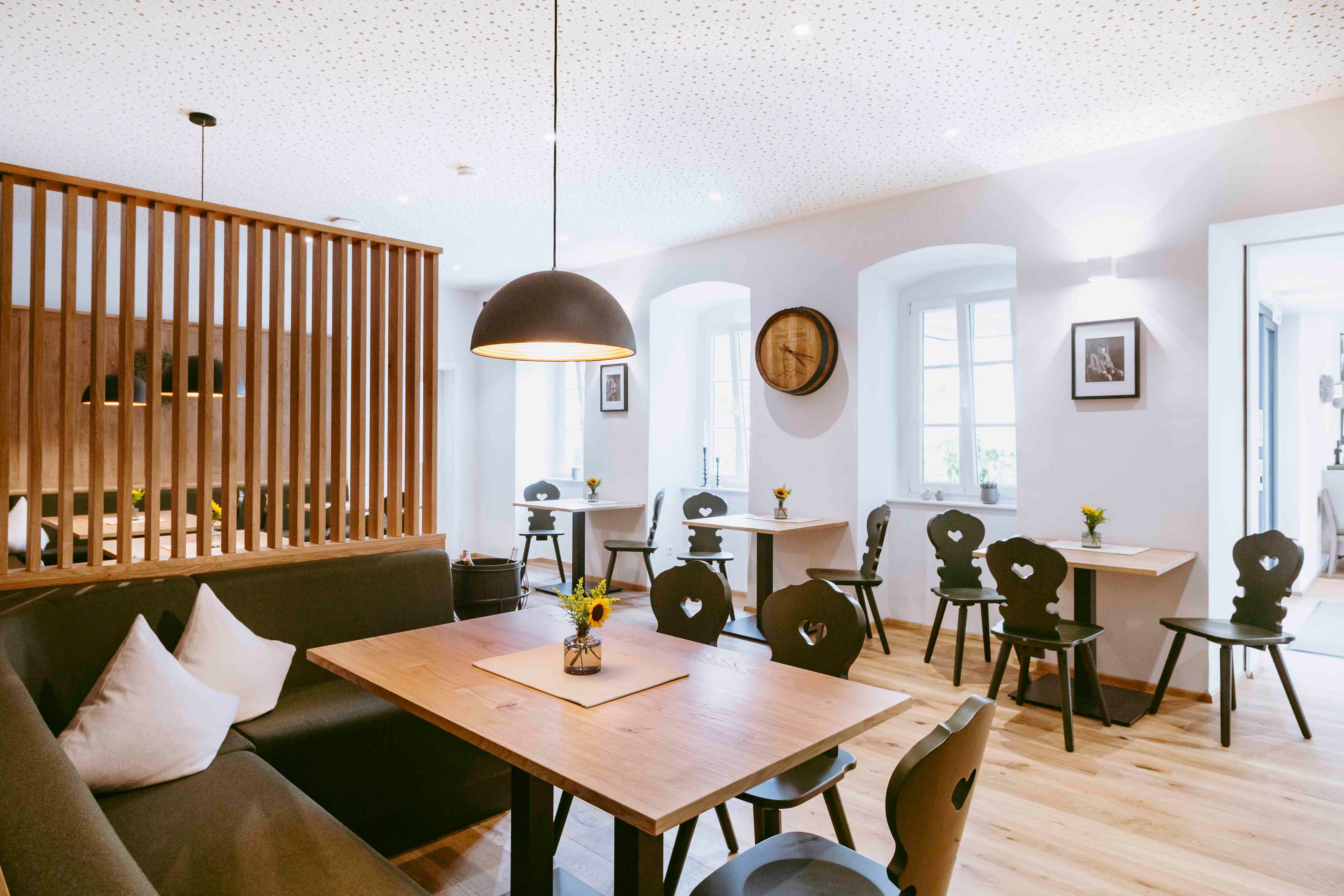 Moderne Gaststube mit Holzmöbeln und stilvoller Beleuchtung.