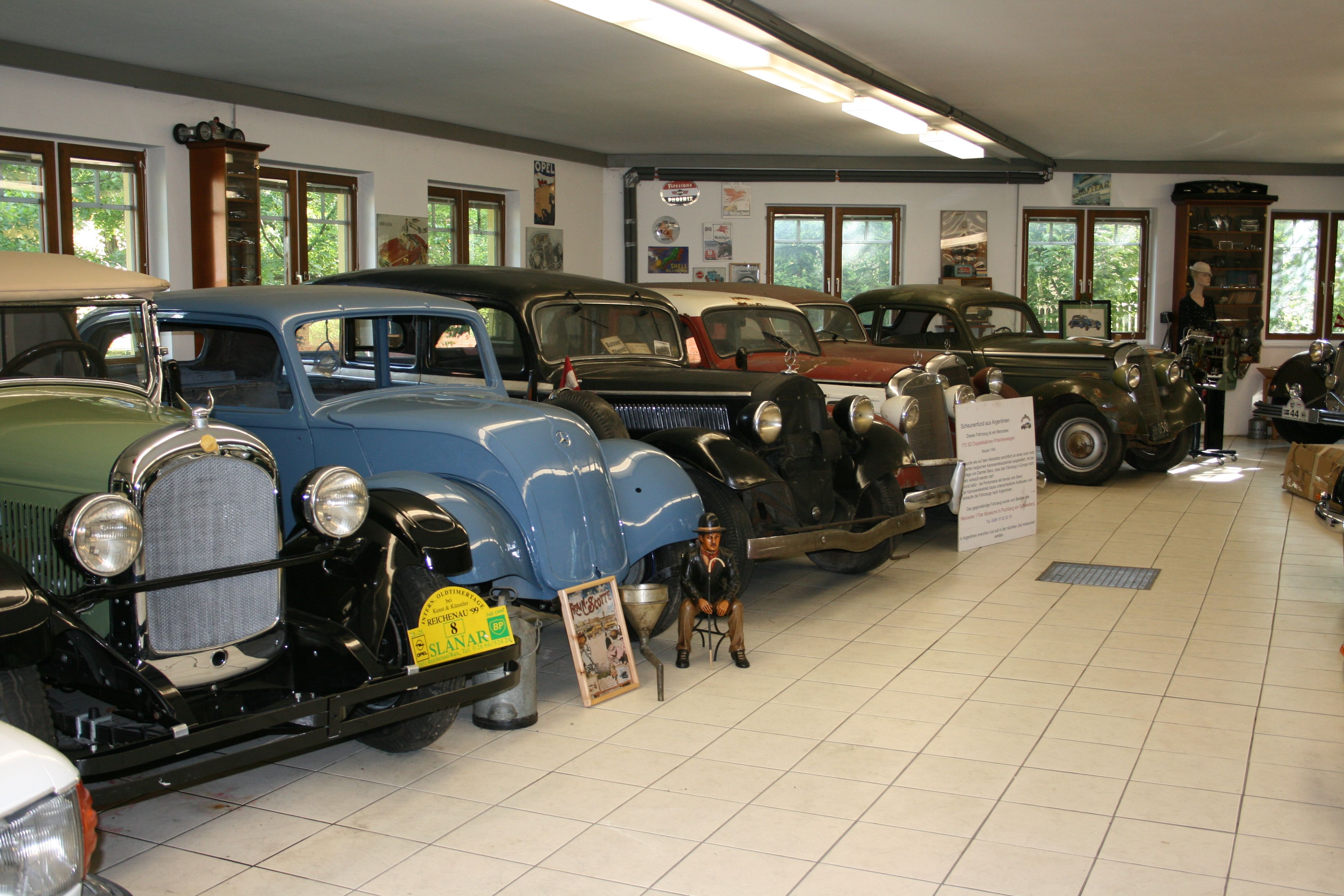 Innenansicht eines Oldtimermuseums mit mehreren klassischen Autos in einer Reihe.