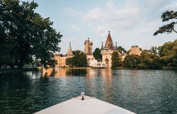 Die sanften Wellen des Wassers spiegeln die majestätische Architektur des Schlosses wider, während die umgebenden Bäume eine ruhige Atmosphäre schaffen. Ein perfekter Ort, um die Schönheit der Natur und die Geschichte in harmonischer Einheit zu erleben.