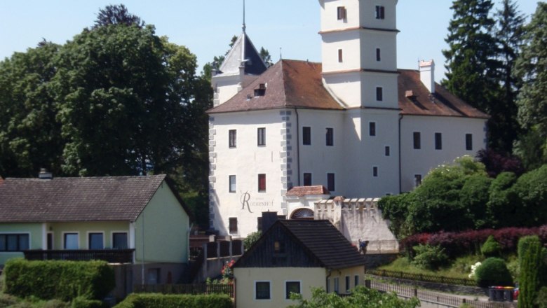 Schloss Rothenhof in Emmersdorf umgeben von Bäumen und Gebäuden.