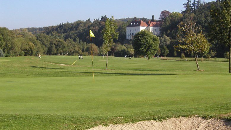 Golfplatz mit Schloss im Hintergrund.