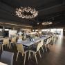 Modernes Restaurant mit Holzst&uuml;hlen und dekorativen Kronleuchtern.