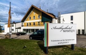 Außenansicht des Amethysthotels Mantler mit Parkplatz und Schild.