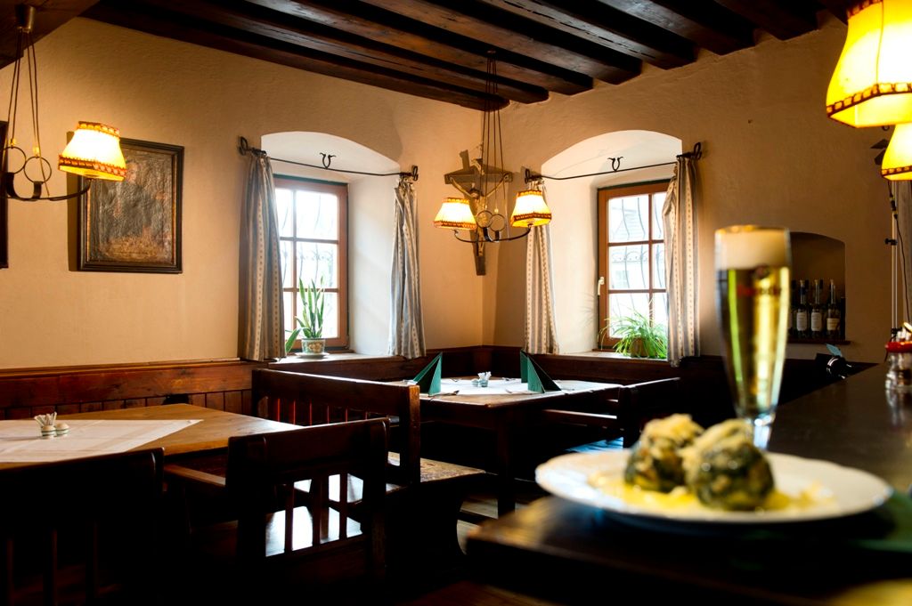 Gemütliches Restaurant mit Holzmöbeln, Bier und Knödeln auf einem Tisch.