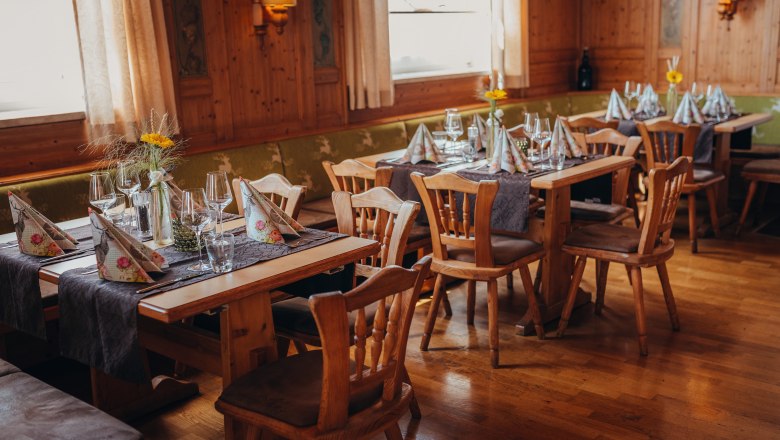 Gem&uuml;tliches Restaurant mit Holzm&ouml;beln und gedeckten Tischen.