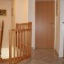 Innenansicht eines Flurs mit Holzt&uuml;ren und Treppengel&auml;nder.