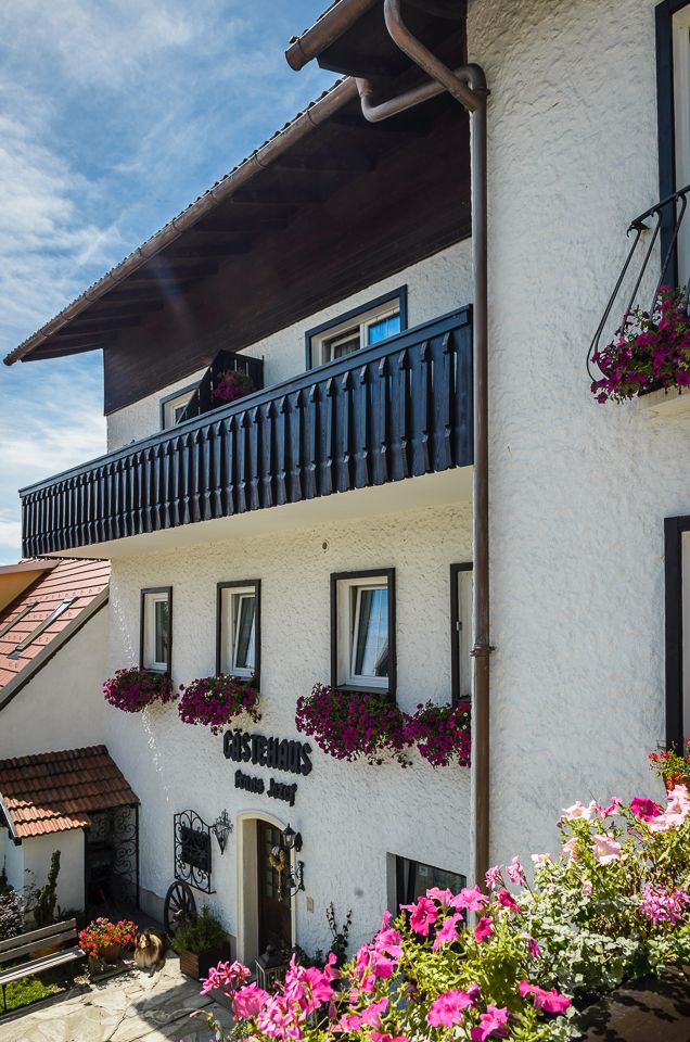 Traditionelles Gästehaus mit Blumen geschmücktem Balkon und Fassade.