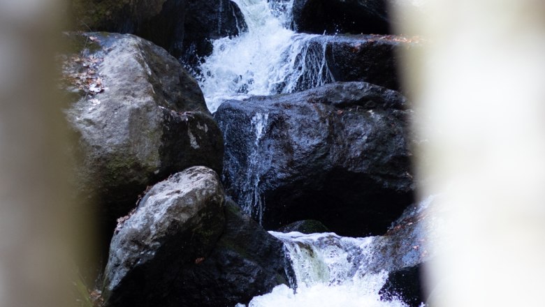 Ein Wasserfall fließt über große Felsen in der Ysperklamm.