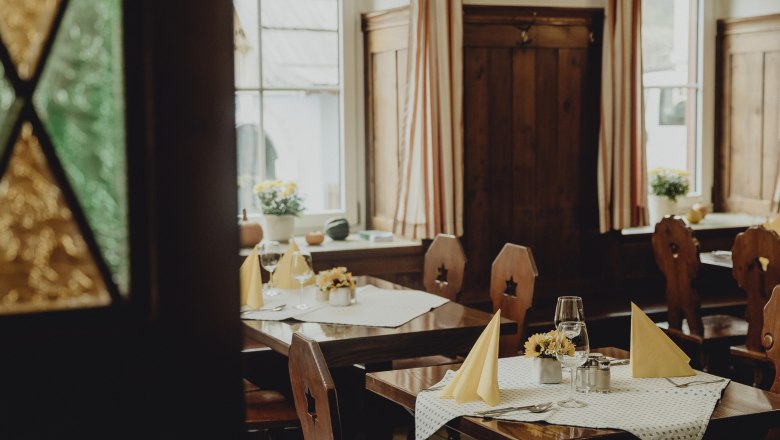 Gemütliches Restaurant mit Holzmöbeln und gedeckten Tischen.
