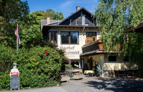 Gasthof Scherrerwirt mit Terrasse und grüner Umgebung.