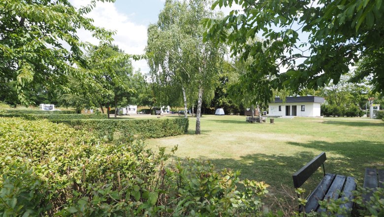 Stellplatz auf einer frisch gem&auml;hten Wiese. Om Hintergrund ein H&auml;uschen f&uuml;r Sanit&auml;ranlage.