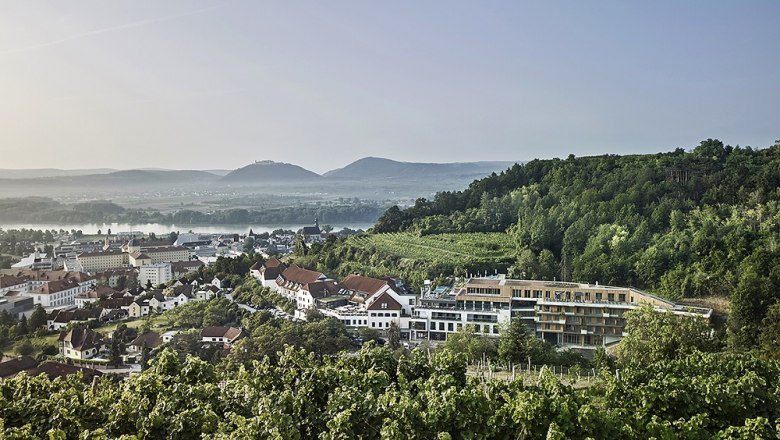 Steigenberger Hotel & Spa Krems, © Steigenberger Hotel & Spa, Gregor Titze Blick auf das Steigenberger Hotel & Spa Krems umgeben von Weinbergen und Hügeln.