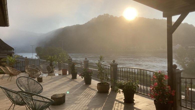 Ausblick von der Terrasse, © Georg Smolka Terrasse mit Blick auf Fluss und Berge im Sonnenaufgang.