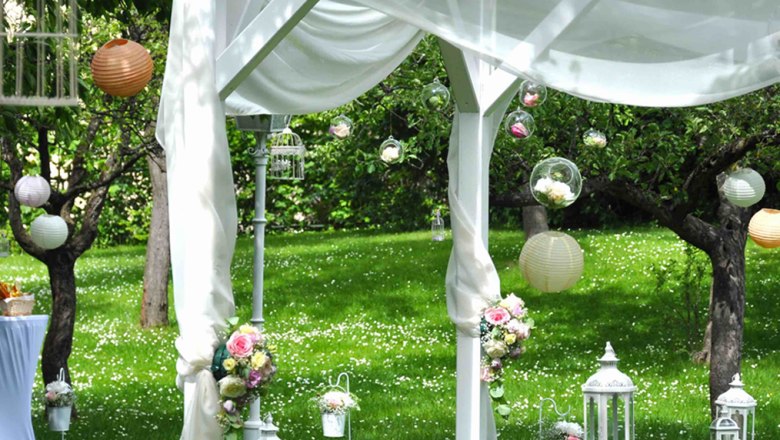 Hochzeitsdekoration im Schlosspark Gloggnitz mit wei&szlig;en Laternen und Blumen.