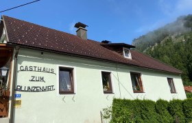 Außenansicht des Gasthauses Zum Blunzenwirt mit grünem Anstrich und braunem Dach.