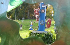 Bunte Skulpturen im Skulpturenpark Semmering, umgeben von grüner Landschaft.