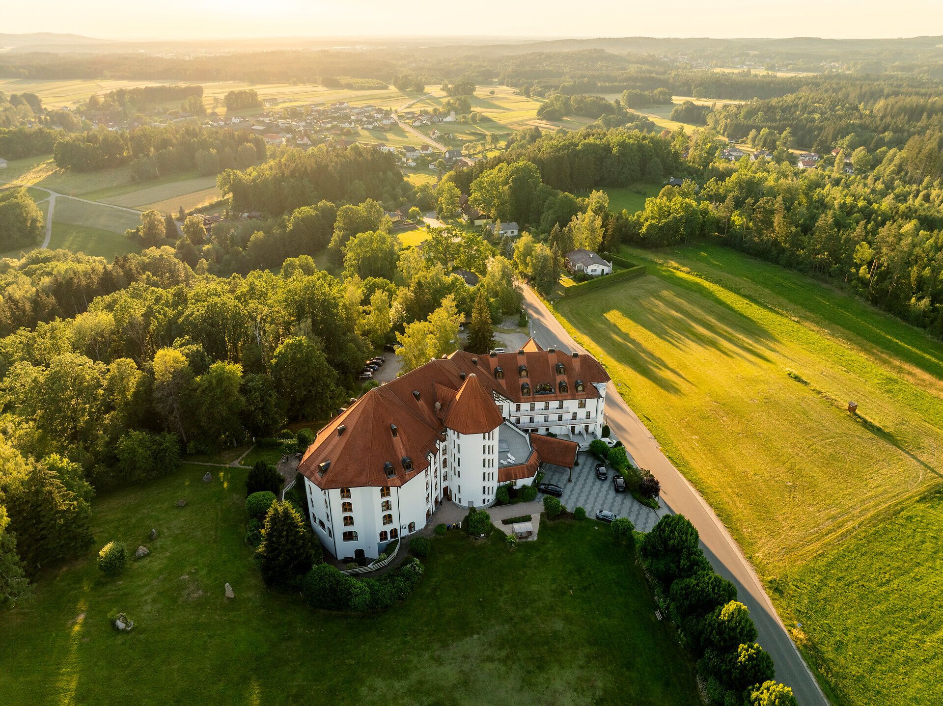 Luftaufnahme des Leonardo Med Spa Resorts im Waldviertel, umgeben von Wiesen, Feldern und Wald.
