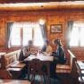 In der gem&uuml;tlichen Atmosph&auml;re einer traditionellen H&uuml;tte genie&szlig;en die G&auml;ste k&ouml;stliche Speisen und die Gesellschaft von Freunden. Das warme Holzinterieur und die sanften Lichtstrahlen schaffen eine einladende Stimmung, die zum Verweilen einl&auml;dt. Hier wird der Winter in den Wiener Alpen zu einem unvergesslichen Erlebnis.