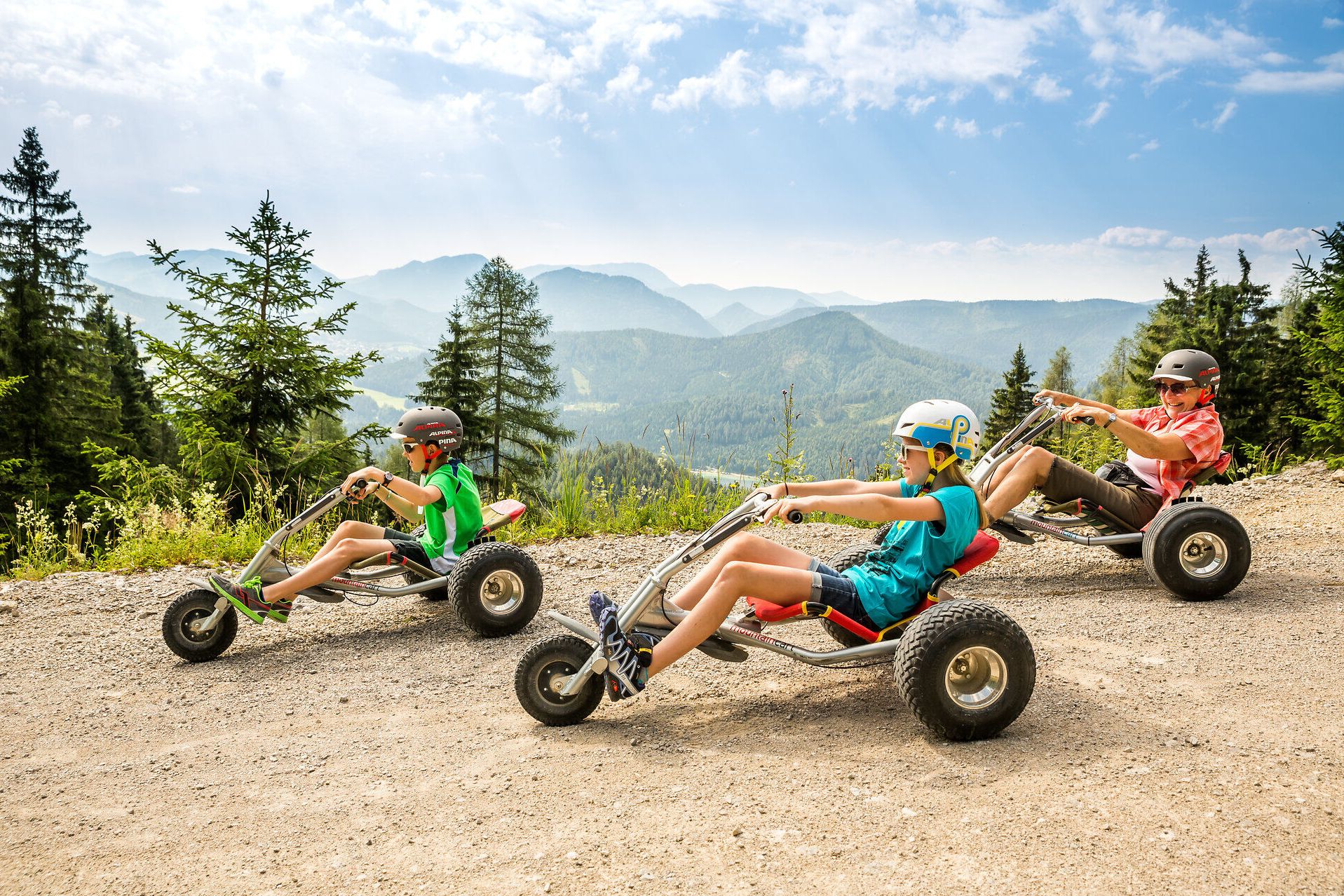 Drei Mountaincart-Fahrer auf der Gemeindealpe MItterbach mit Bergpanorama im Hingergrund