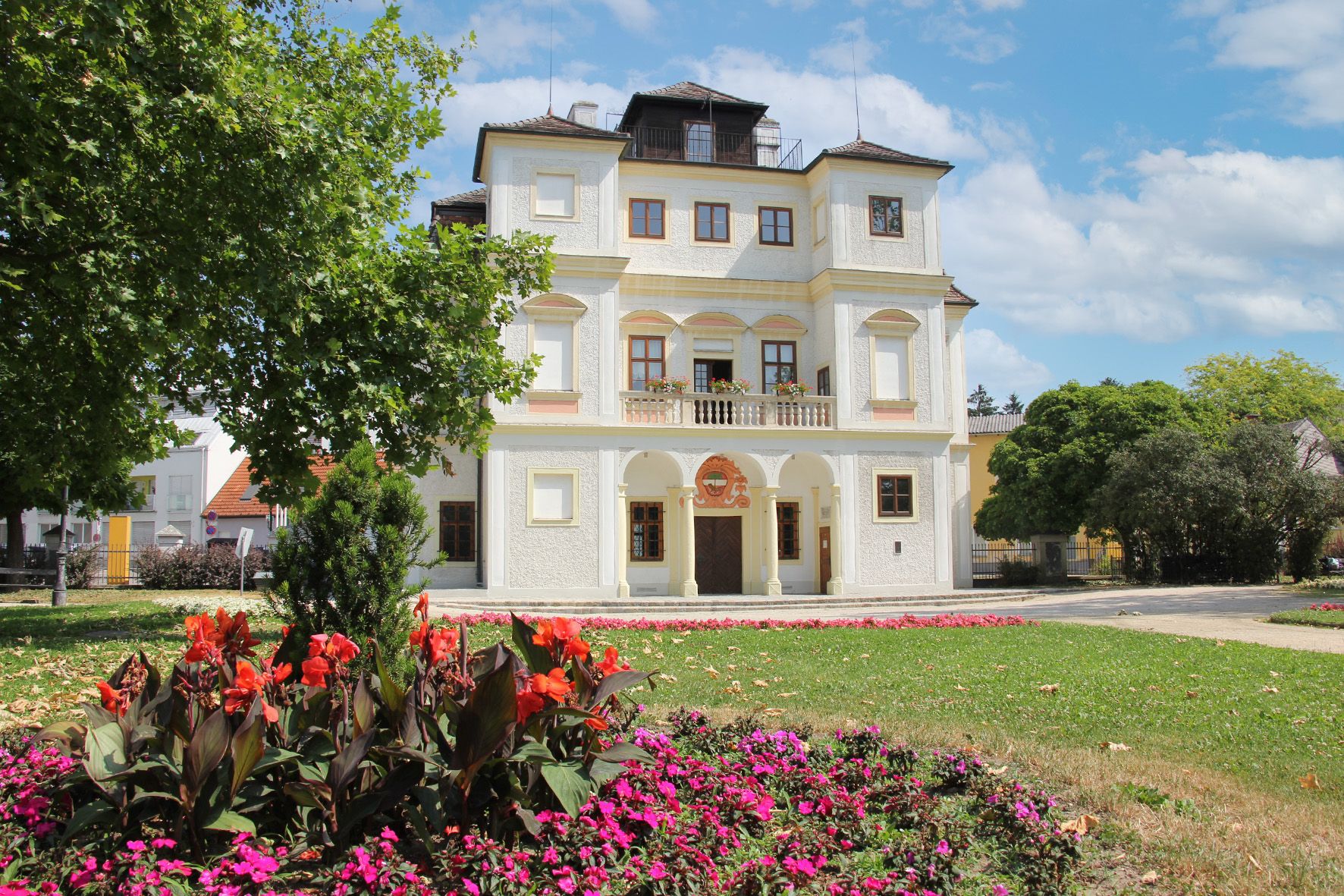 Belvedereschlössl in Stockerau mit Blumenbeet im Vordergrund.