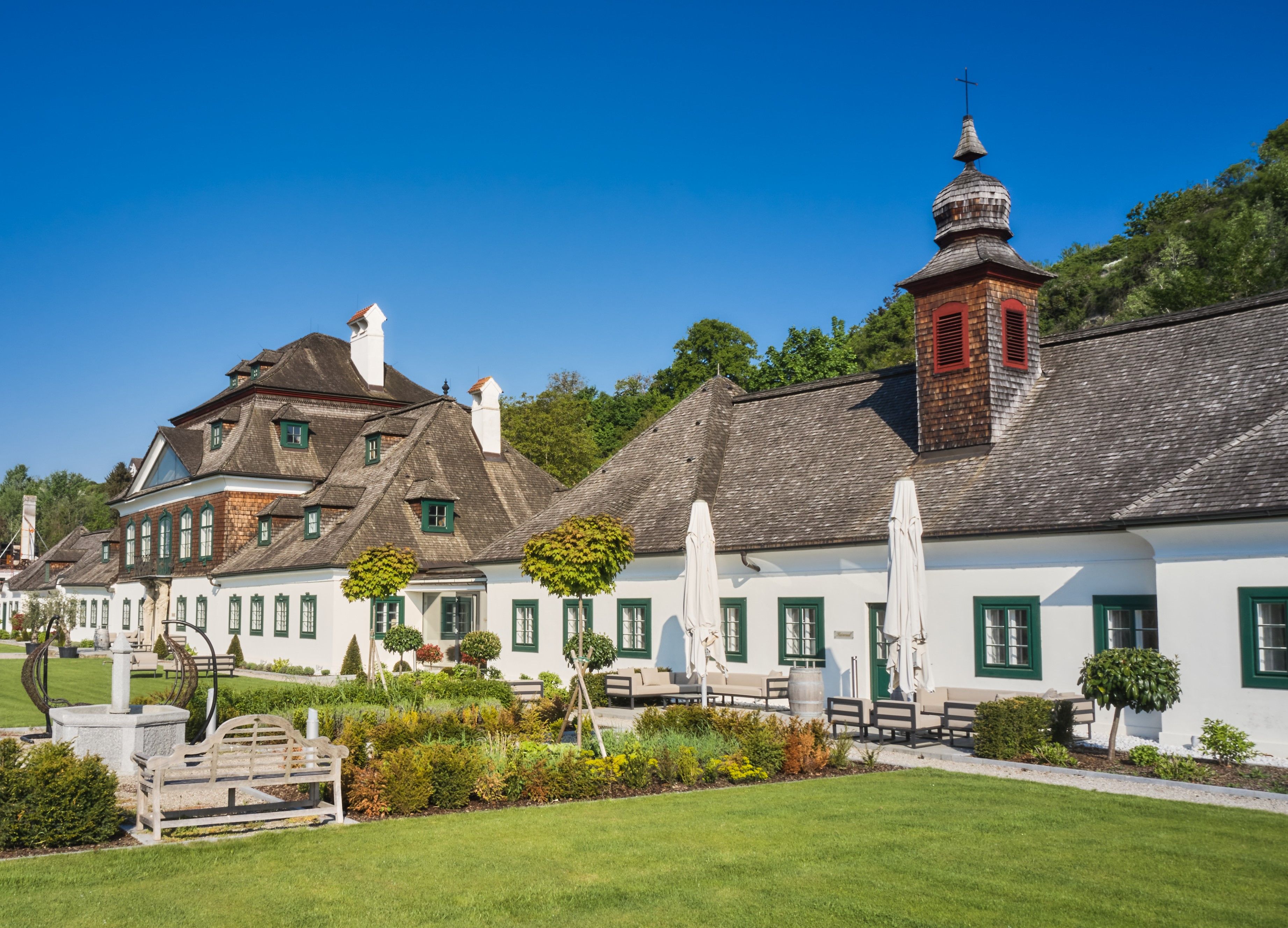 Schloss Luberegg mit gepflegtem Garten und blauen Himmel.