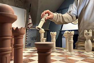 Schachspiel auf der Schallalburg_ Hände halten große Schachfiguren 