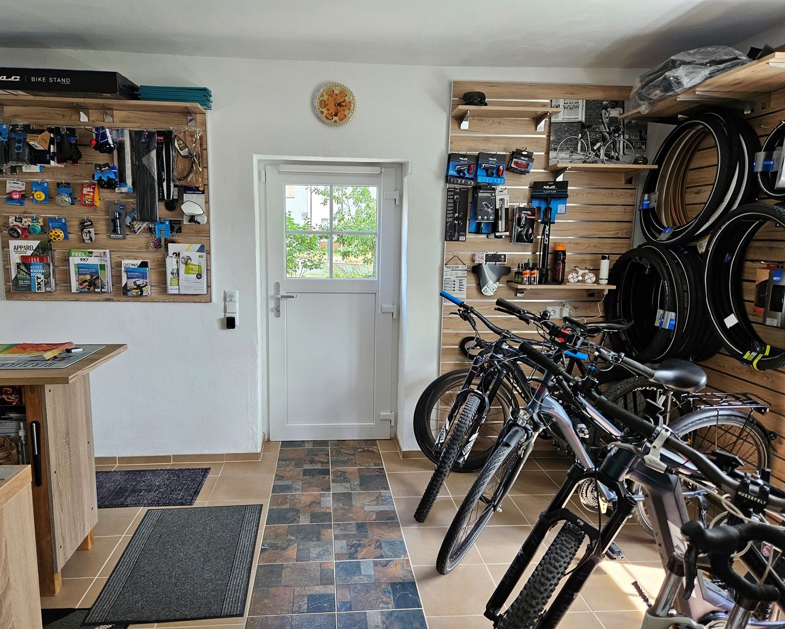 Innenansicht einer Fahrradwerkstatt mit Fahrrädern und Zubehör an den Wänden.